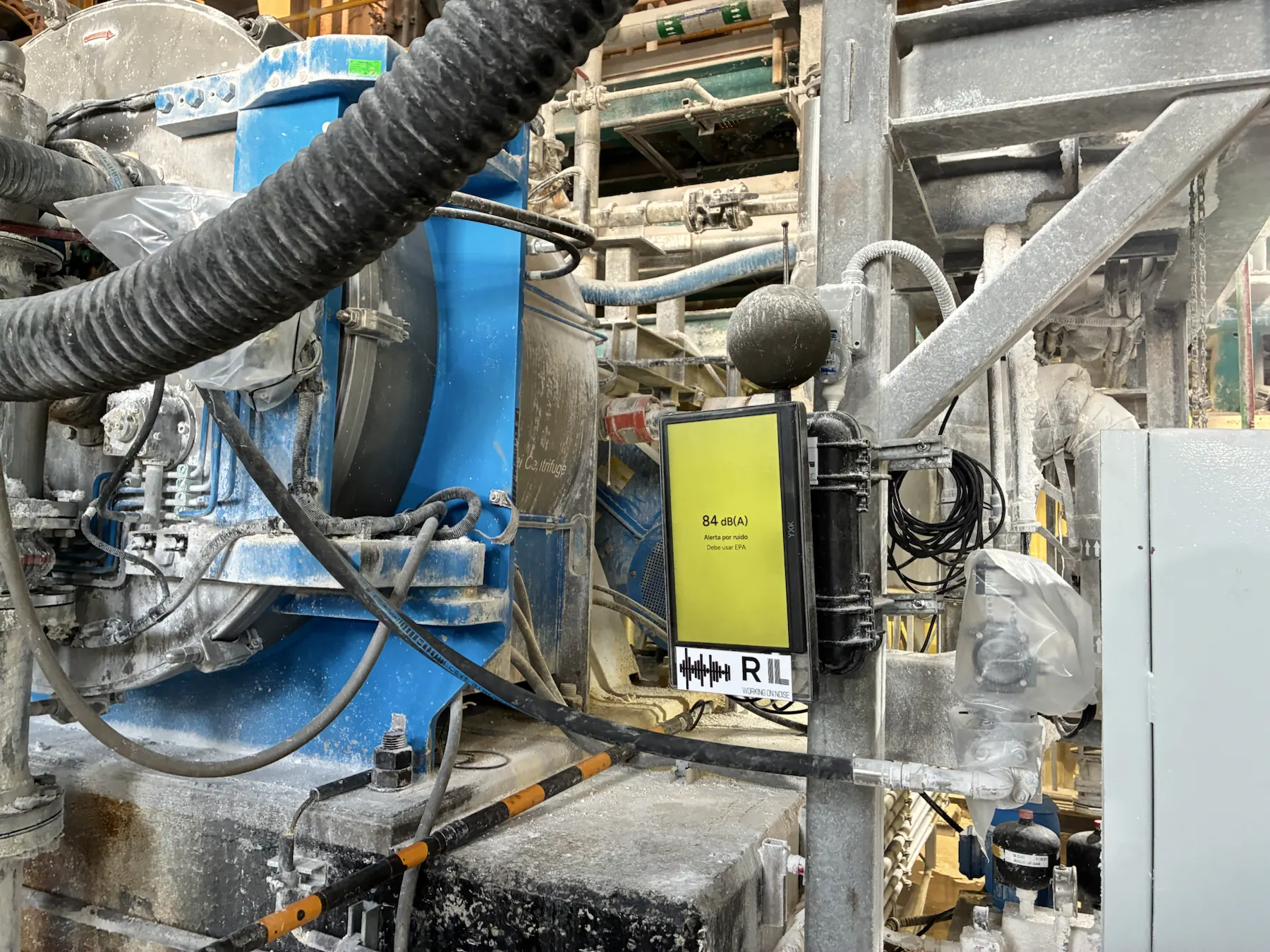 Estacion RIL instalada en planta industrial con pantalla de alerta por ruido.